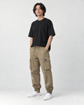 Model wearing the khaki cargo joggers with a black tee and white sneakers, three-quarter view
