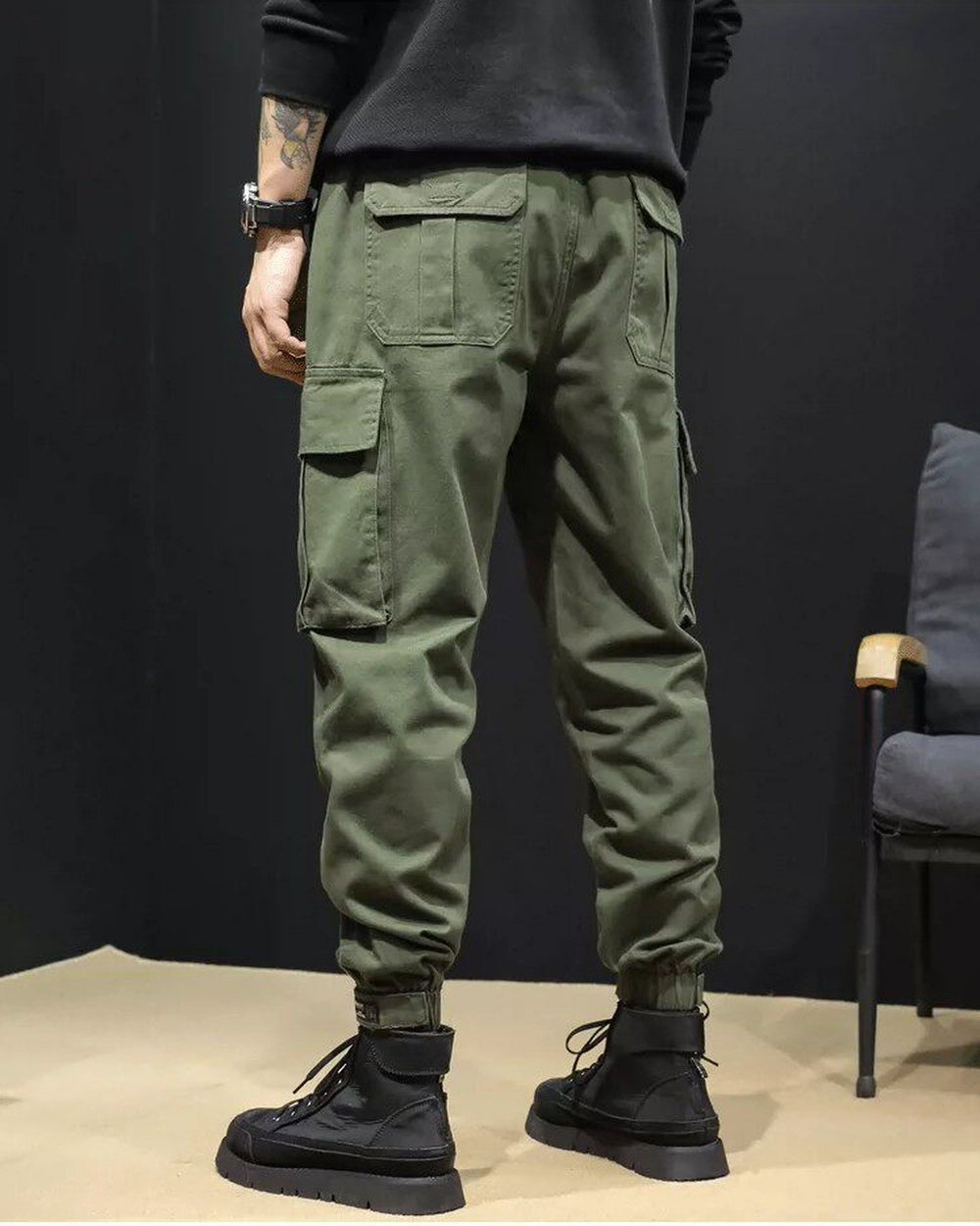 Close-up of the large flap pocket on the thigh of the army green cargo joggers
