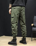 Close-up of the large flap pocket on the thigh of the army green cargo joggers