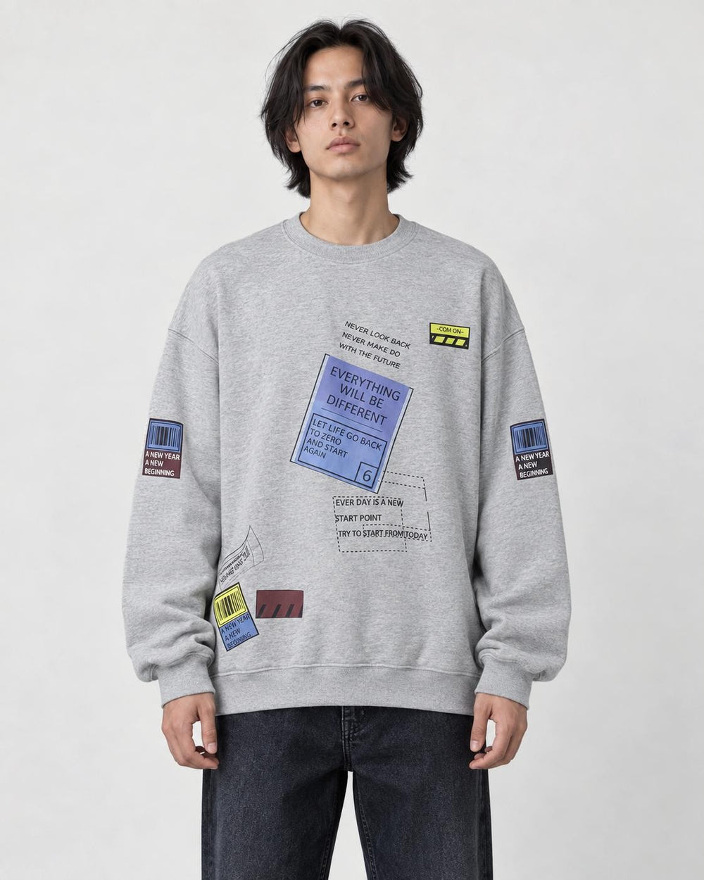 Model wearing the light gray label-print crewneck sweatshirt with dark jeans, front view