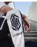 Close view of the hexagon emblem and script lettering on the white lower leg of the black joggers
