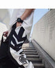 Side view of the black joggers showing the white chevron panel and the striped hexagon emblem