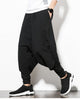 Black layered harem pants, side view, showing the baggy outer layer over the fitted inner layer