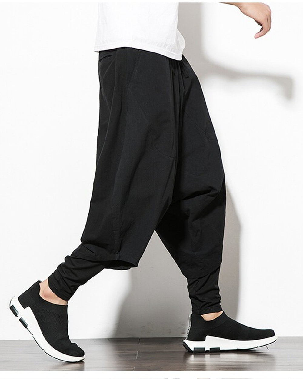 Black layered harem pants in motion, showing the low crotch and the fitted inner leg
