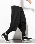 Black layered harem pants in motion, showing the low crotch and the fitted inner leg