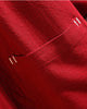 Close-up of a patch pocket with white bar-tack stitches on the red linen haori cardigan