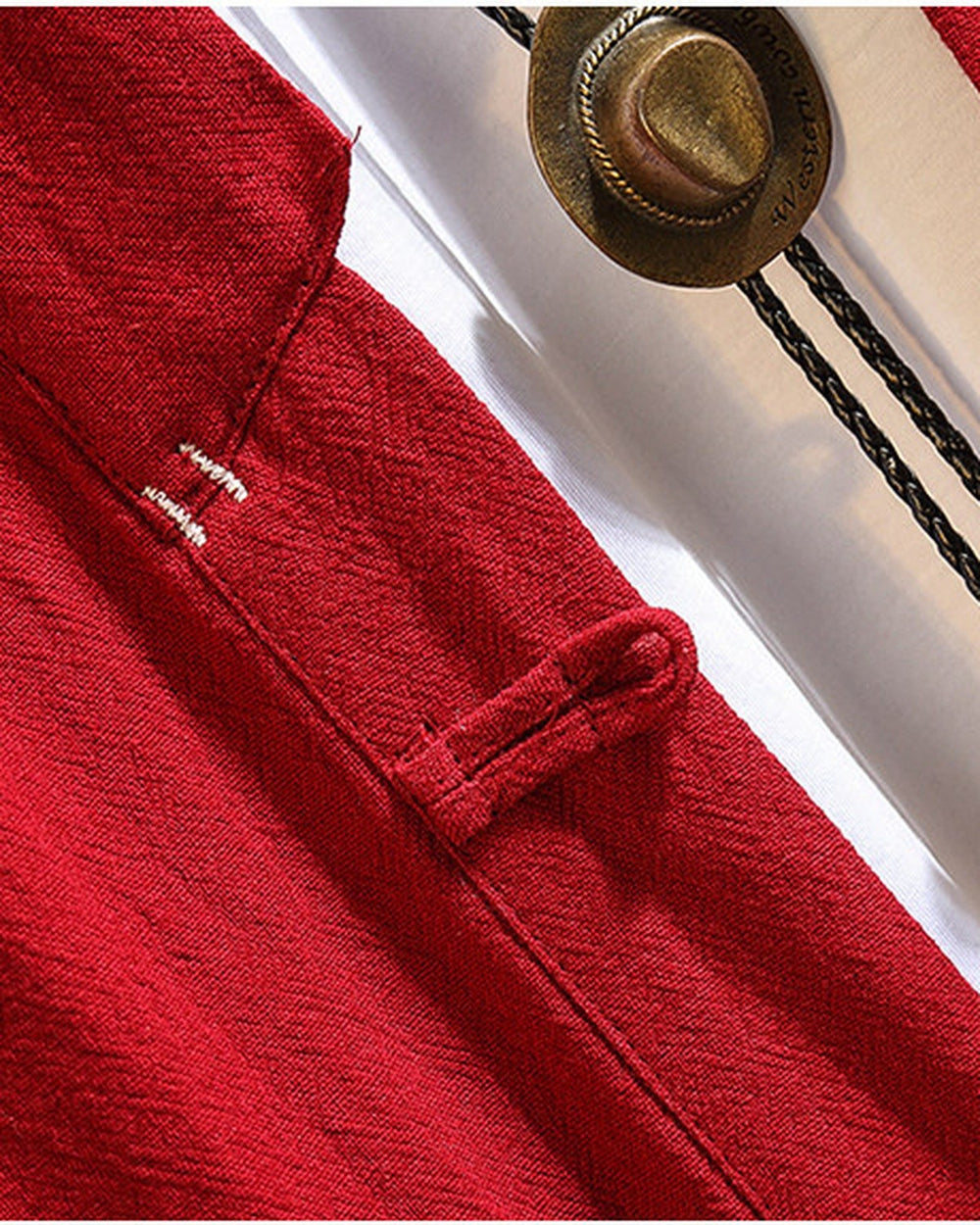 Close-up of the cloth frog-button toggle and the white stitches on the red linen haori cardigan