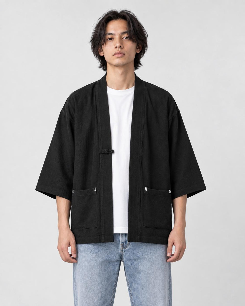 Model wearing the black linen haori cardigan open over a white tee and light-wash jeans, front view