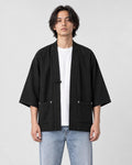 Model wearing the black linen haori cardigan open over a white tee and light-wash jeans, front view
