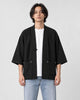 Model wearing the black linen haori cardigan open over a white tee and light-wash jeans, front view