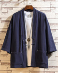 Navy linen haori cardigan hanging open over a white tee, showing the patch pockets and the cloth toggle