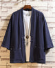 Navy linen haori cardigan hanging open over a white tee, showing the patch pockets and the cloth toggle