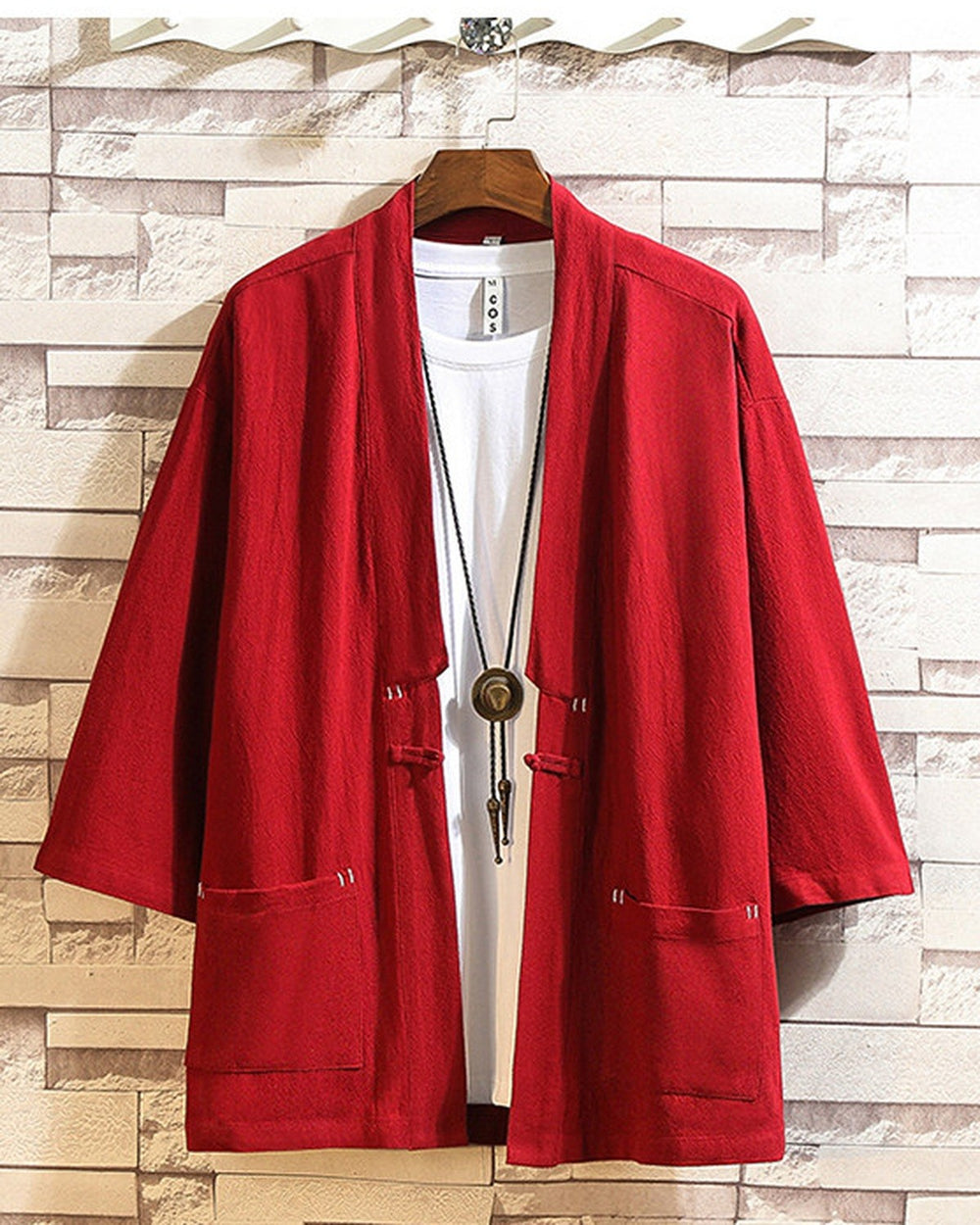 Red linen haori cardigan hanging open over a white tee, showing the patch pockets and the cloth toggle