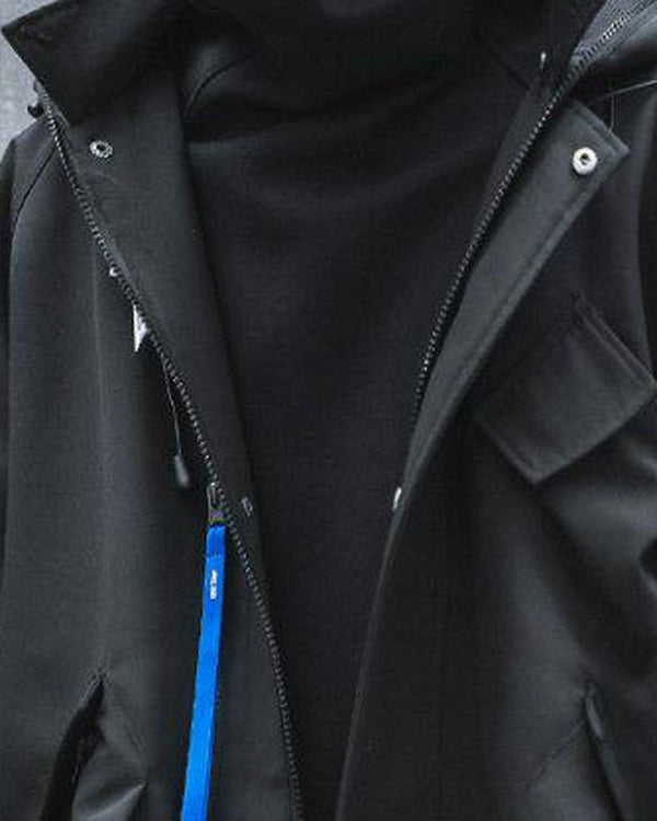 Close view of the black hooded jacket with the high collar, snap placket, chest pocket and blue zip pull