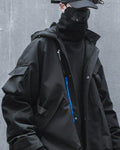 Man in the black hooded jacket with the hands in the pockets, three-quarter view of the front