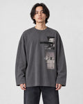 Model wearing the charcoal loose long sleeve tee with a photo print on the chest, dark jeans and white sneakers