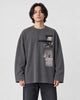 Model wearing the charcoal loose long sleeve tee with a photo print on the chest, dark jeans and white sneakers