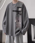Charcoal loose long sleeve tee with a black bar and two photo panels on the chest, worn with gray sweatpants