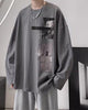 Charcoal loose long sleeve tee with a black bar and two photo panels on the chest, worn with gray sweatpants