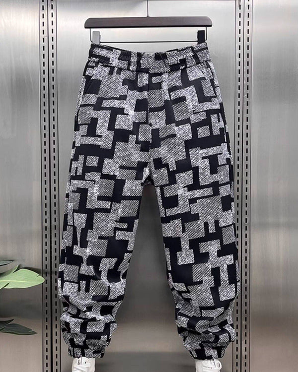Front view of joggers printed with black and white-gray maze blocks, hanging with gathered ankle cuffs