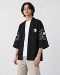 Man in the open black haori over a white tee, turned slightly, showing the sleeve art