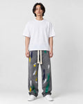 Model wearing the washed gray paint-splatter wide-leg jeans with a white tee and white sneakers, front view