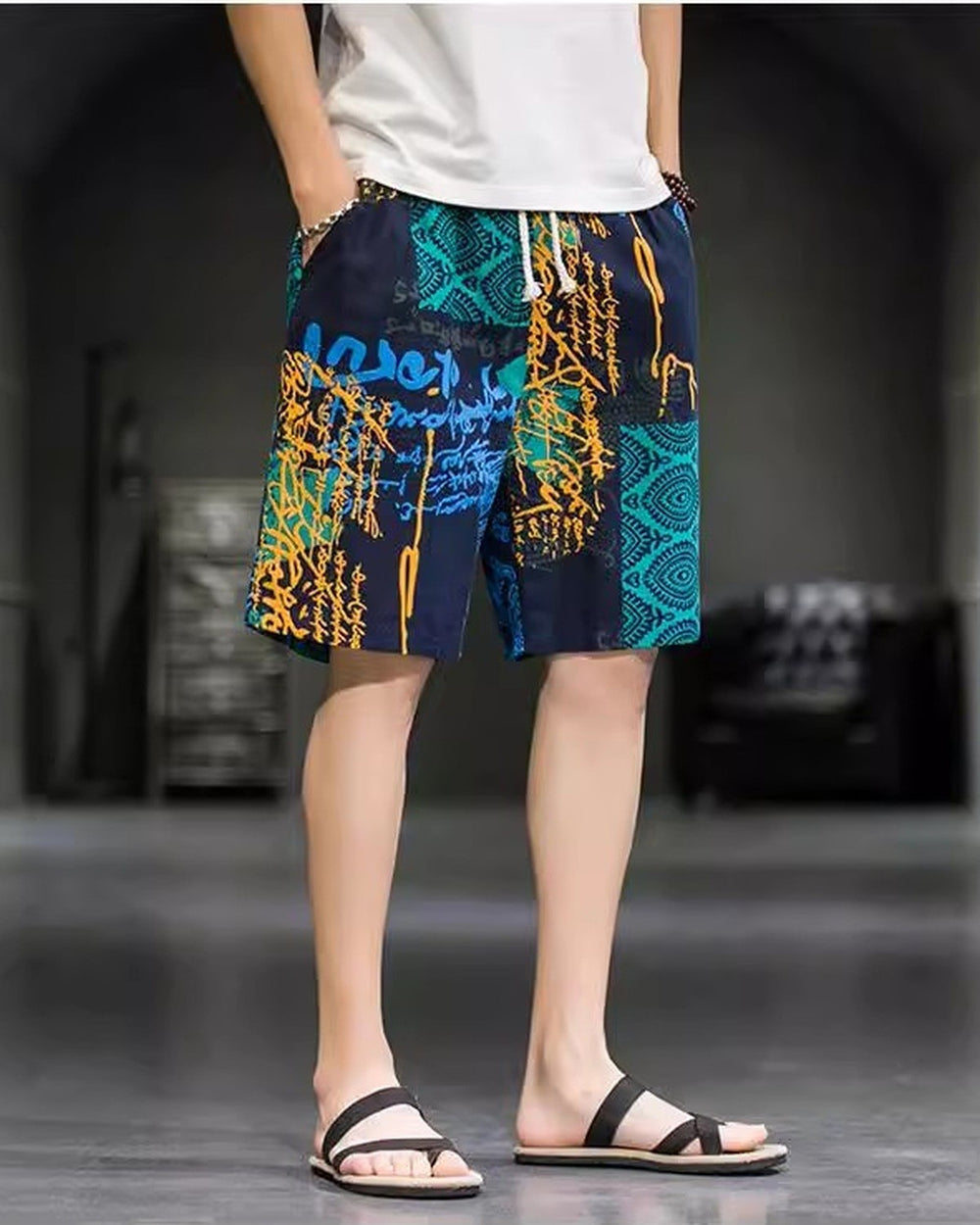 Navy and teal patchwork print shorts, standing pose, showing the orange-yellow strokes and the teal panel