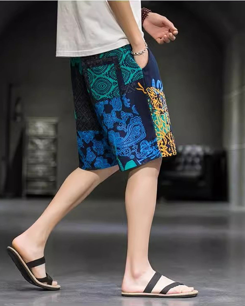 Navy and teal patchwork print shorts in motion, side view, showing the blue paisley panel