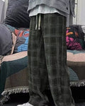 Army green plaid wide-leg pants worn standing, knee to ankle