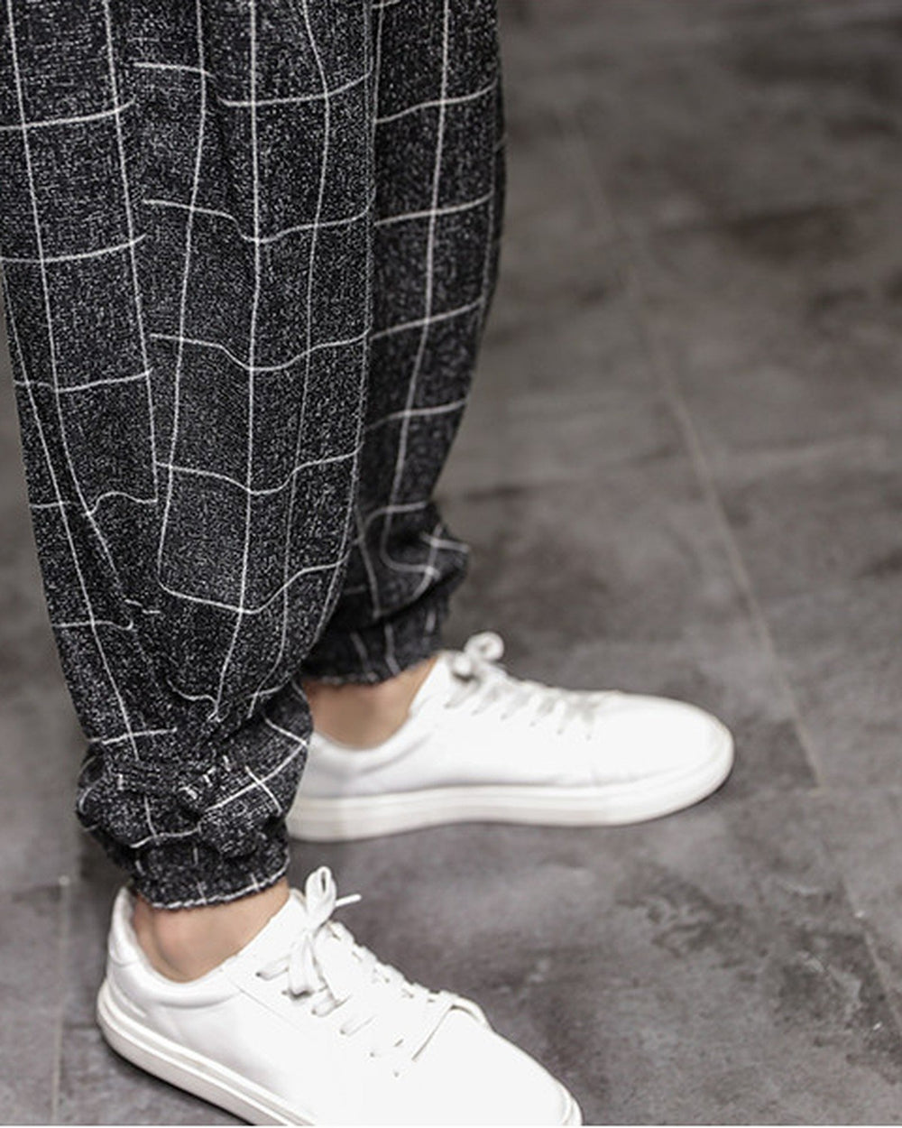 Close-up of the gathered elastic cuff with a frog-button knot on the black plaid harem pants