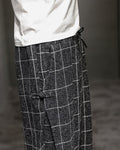 Close-up of the frog-button knot at the hip on the black plaid harem pants