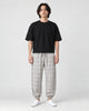 Model wearing the cream plaid harem pants with a black tee and white sneakers, front view