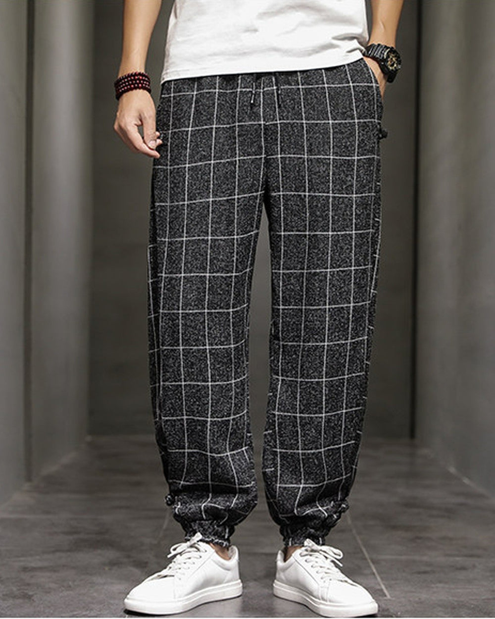 Black plaid harem pants with frog-button knots at the hips, worn with a white tee and white sneakers