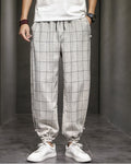 Cream plaid harem pants with frog-button knots at the hips, worn with a white tee and white sneakers