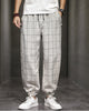 Cream plaid harem pants with frog-button knots at the hips, worn with a white tee and white sneakers