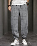 Gray plaid harem pants with frog-button knots at the hips, worn with a white tee and white sneakers