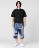 Model wearing the blue patchwork cropped pants with a black tee and white sneakers, front view