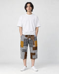 Model wearing the brown patchwork cropped pants with a white tee and white sneakers, front view