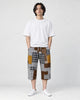 Model wearing the brown patchwork cropped pants with a white tee and white sneakers, front view