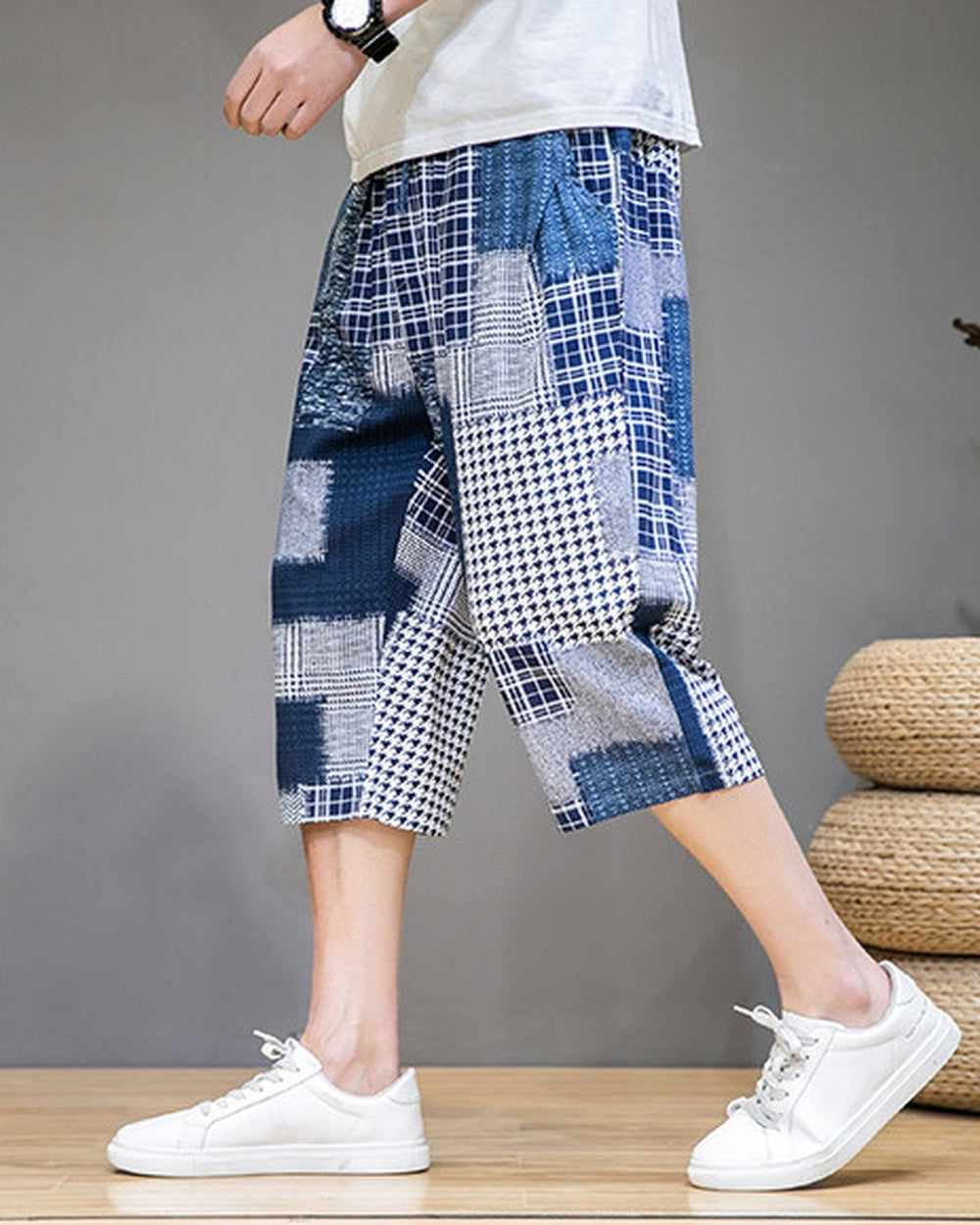 Blue patchwork cropped pants in motion, seen from the side, ending at mid-calf