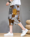 Brown patchwork cropped pants in motion, seen from the side, ending at mid-calf