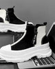 Black and white platform sneaker boots from the side, showing the white zig-zag zip tape and the NICE MEE pull