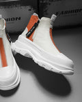 Orange and white platform sneaker boots with a front zip and a NICE MEE pull, a studio pair on a gray floor