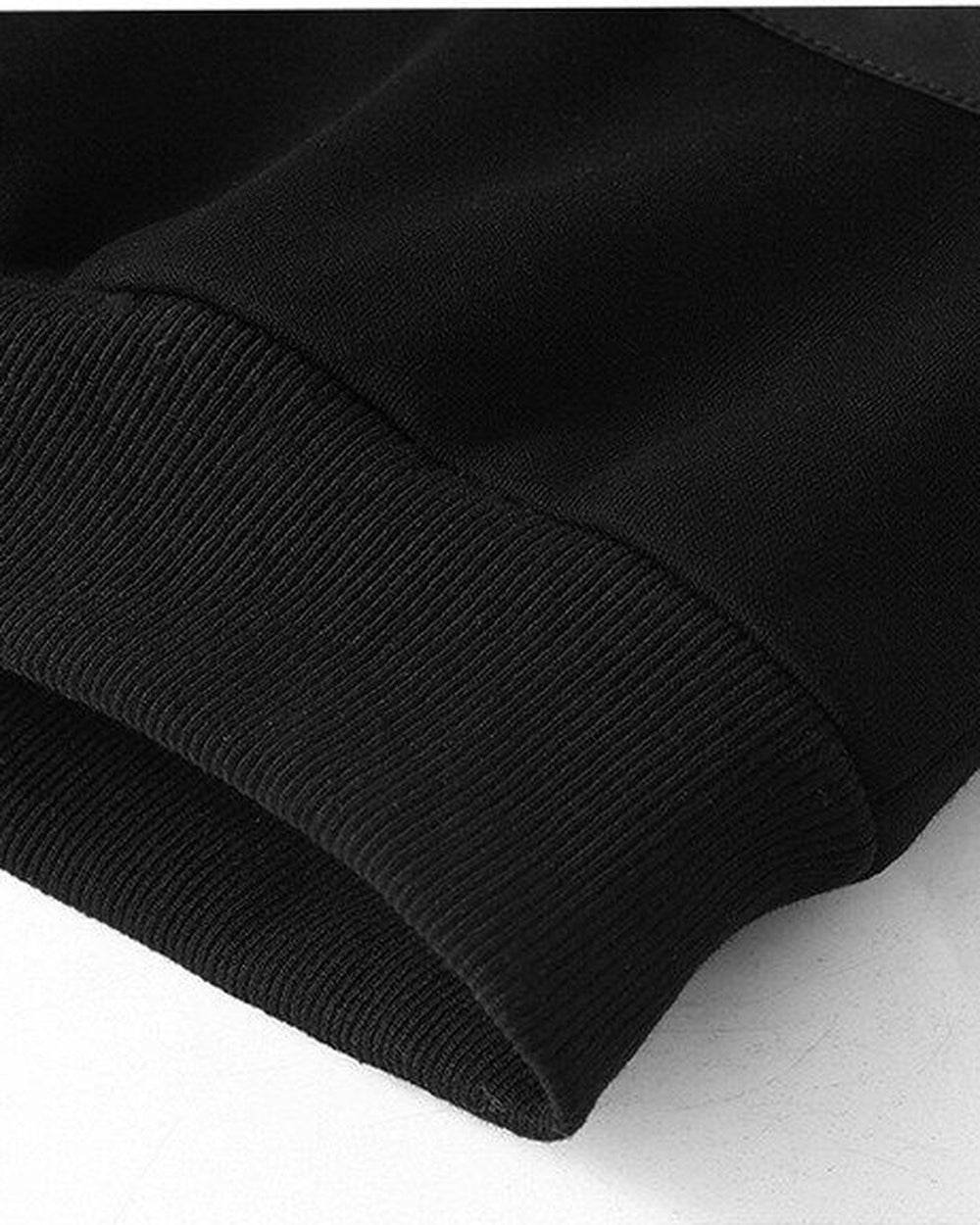 Close-up of the ribbed hem of the black fleece-lined sweatshirt