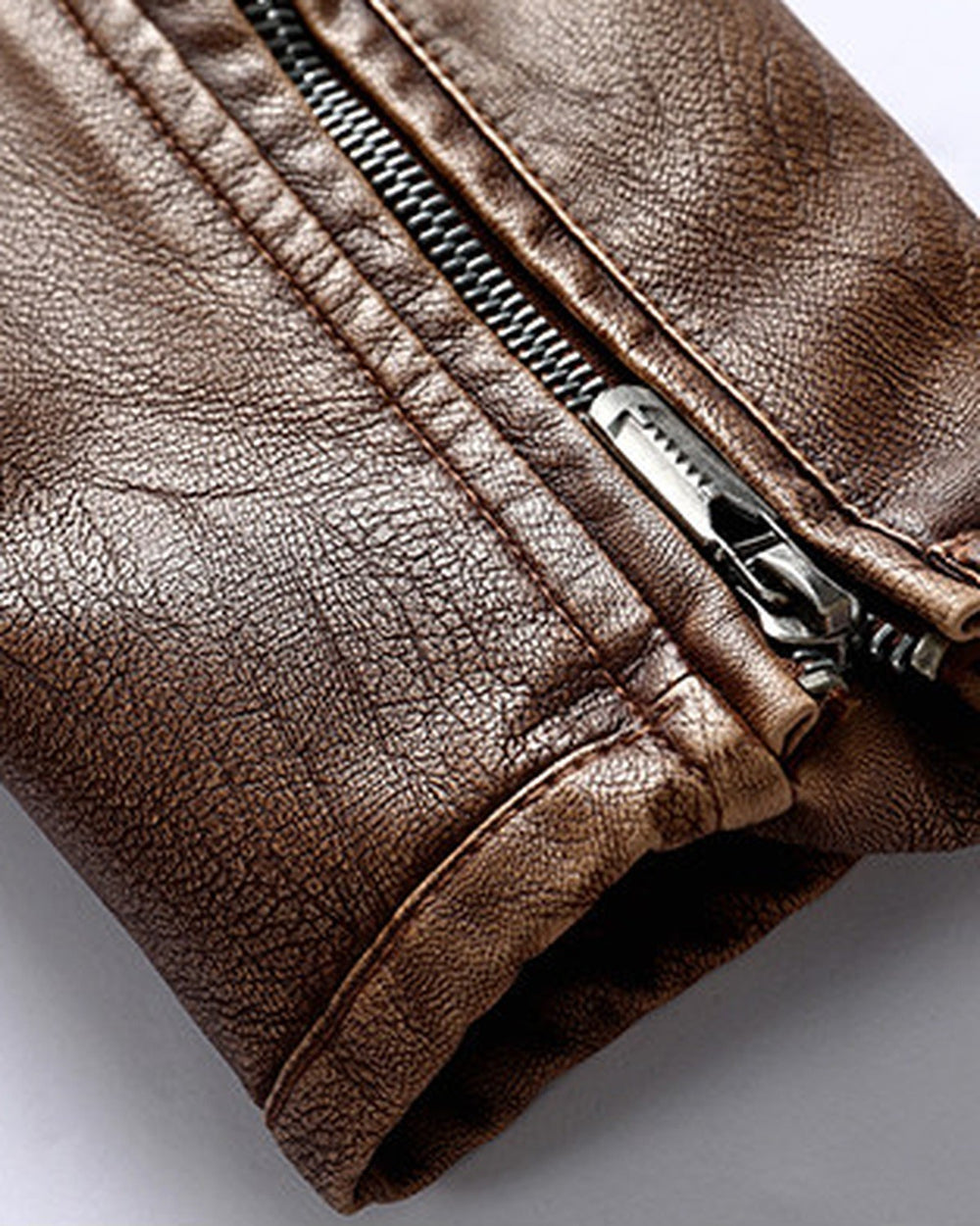 Close-up of the short metal zip on the cuff of the brown biker jacket