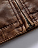 Close-up of the stitched hem band and the centre zip of the brown biker jacket