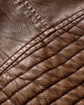 Close-up of the ribbed padding on the upper sleeve of the brown biker jacket