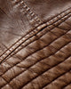 Close-up of the ribbed padding on the upper sleeve of the brown biker jacket