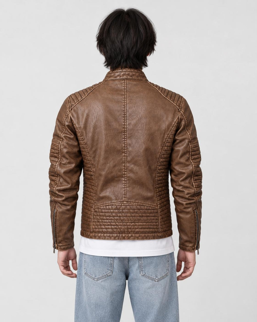 Back of the brown biker jacket on a model, showing the quilted shoulders, centre seam and quilted lower band