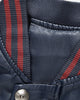 Close view of the striped rib collar and snap on the navy varsity jacket